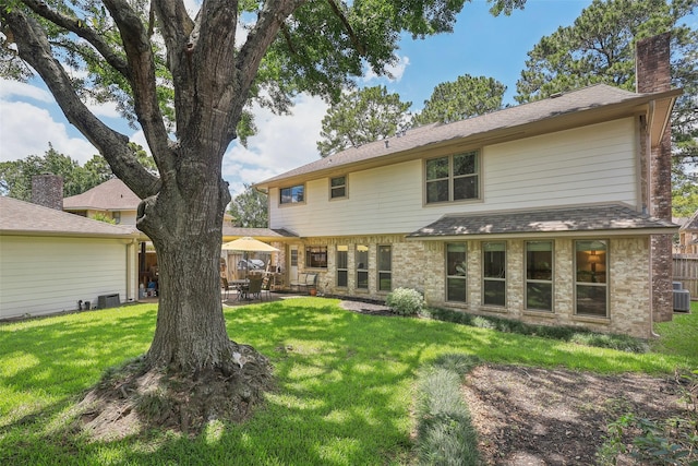 rear view of house with a chimney, a patio, brick siding, and cooling unit