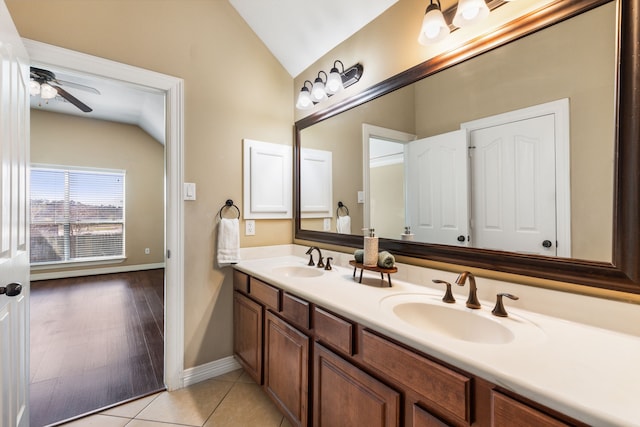 full bath with vaulted ceiling, ceiling fan, double vanity, baseboards, and tile patterned flooring