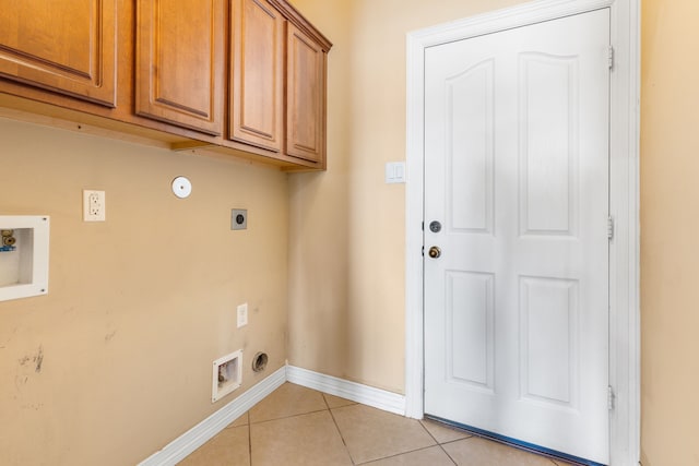 washroom featuring electric dryer hookup, light tile patterned floors, cabinet space, washer hookup, and baseboards