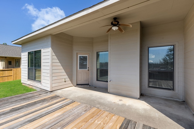 wooden deck featuring ceiling fan, fence, and a patio area