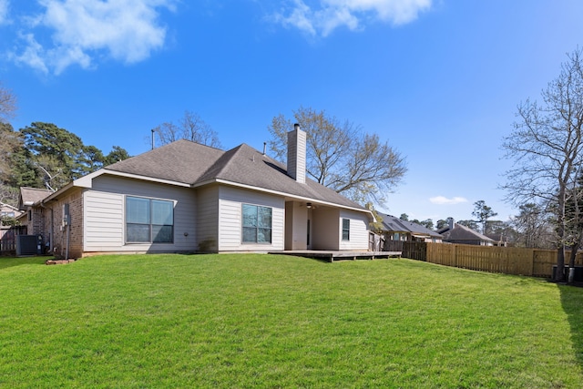 rear view of property featuring a chimney, ceiling fan, central air condition unit, brick siding, and roof with shingles