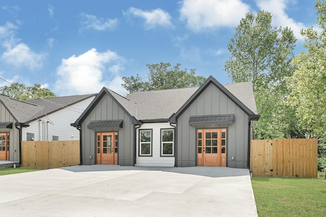 204 S 4th St, Conroe, TX 77301 - back of house featuring board and batten siding, roof with shingles, and fence