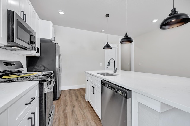 204 S 4th St, Conroe, TX 77301 - kitchen with appliances with stainless steel finishes, a sink, light wood finished floors, white cabinetry, and light countertops
