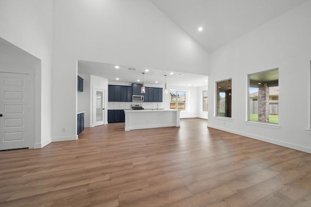 21705 Southern Valley Ln, New Caney, TX 77357 - unfurnished living room with high vaulted ceiling, light wood finished floors, and recessed lighting