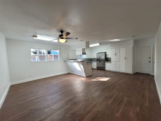 4302 Dickson St, Houston, TX 77007 - kitchen featuring stainless steel fridge, a peninsula, white cabinets, baseboards, and dark wood-type flooring