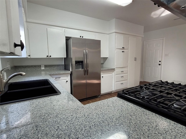 4302 Dickson St, Houston, TX 77007 - kitchen featuring stainless steel fridge, a sink, white cabinets, dark wood-style flooring, and light stone countertops