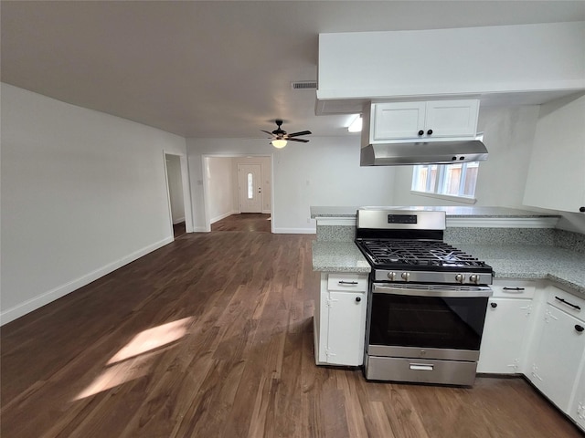 4302 Dickson St, Houston, TX 77007 - kitchen with stainless steel gas range oven, under cabinet range hood, dark wood finished floors, white cabinetry, and baseboards