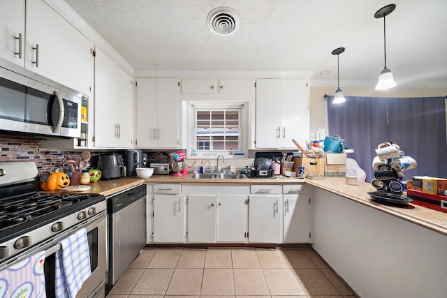 23114 Laura, New Caney, TX 77357 - kitchen with appliances with stainless steel finishes, a sink, decorative backsplash, a textured ceiling, and light countertops