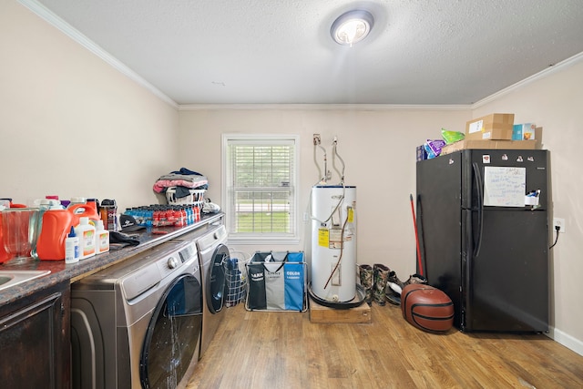 23114 Laura, New Caney, TX 77357 - clothes washing area featuring water heater, washing machine and clothes dryer, light wood-style flooring, crown molding, and a textured ceiling