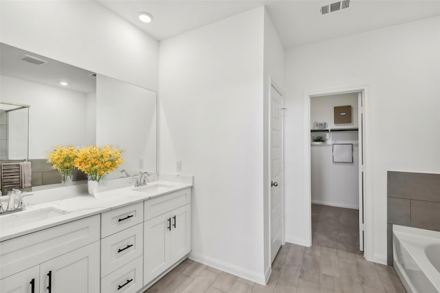21806 Ash Cypress Ct, Cypress, TX 77433 - bathroom with wood finish floors, a tub to relax in, double vanity, and baseboards