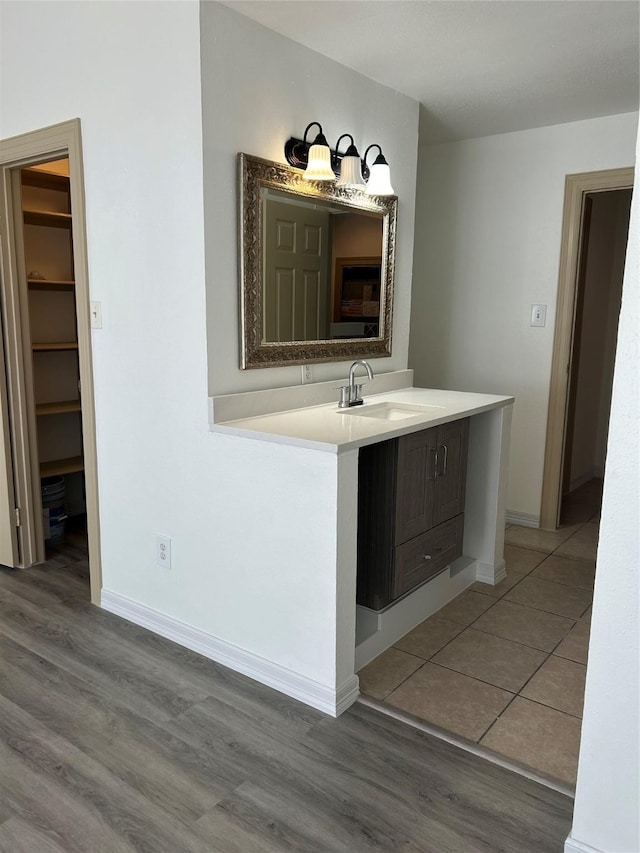 8702 Victorian Village Dr Unit 8702, Houston, TX 77071 - bathroom with a sink, wood finished floors, baseboards, and a spacious closet