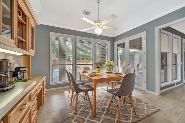 dining room featuring baseboards, ceiling fan, crown molding, and light tile patterned flooring