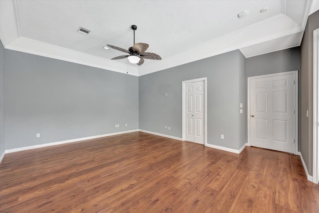spare room with ceiling fan, wood finished floors, baseboards, and ornamental molding