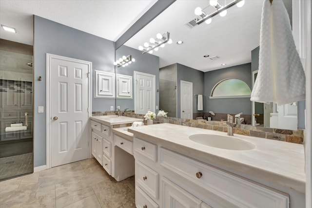 full bath with a tile shower, double vanity, and baseboards