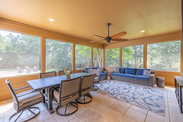 sunroom / solarium with a textured ceiling, recessed lighting, and view of scattered trees