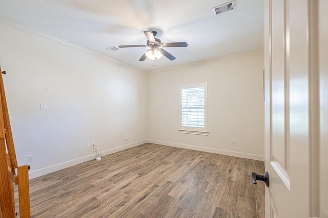 unfurnished room featuring wood finished floors, crown molding, ceiling fan, and baseboards
