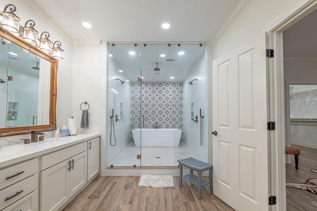 full bathroom featuring wood finished floors, a stall shower, ornamental molding, vanity, and recessed lighting