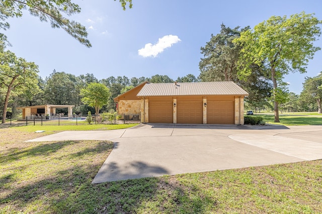 view of property exterior featuring metal roof, a detached garage, and an outbuilding