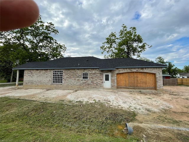 3485 Pradice St, Beaumont, TX 77705 - rear view of property featuring a garage, fence, and brick siding