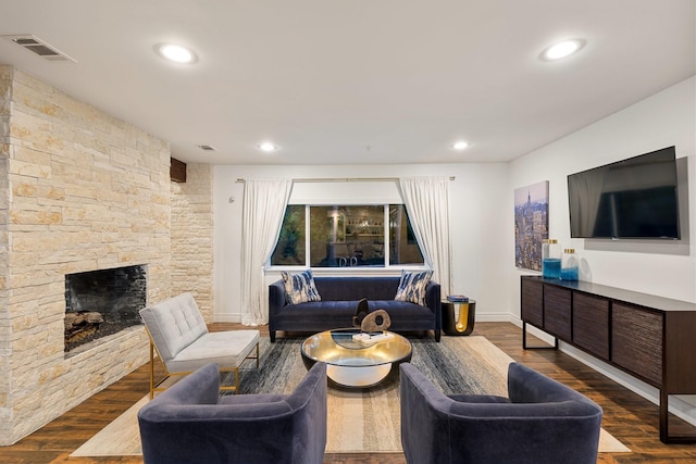living room featuring wood finished floors, a fireplace, baseboards, and recessed lighting