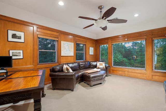 carpeted living area featuring recessed lighting, a ceiling fan, and wooden walls