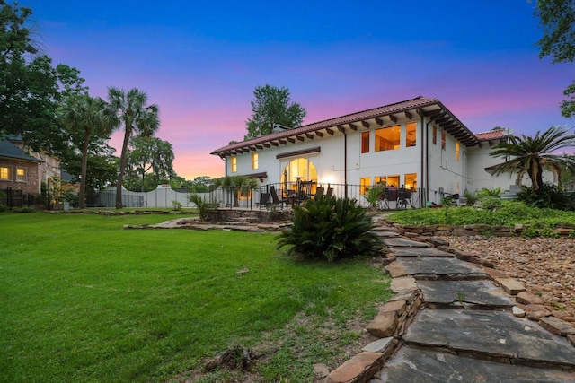 back of property with a tiled roof and stucco siding