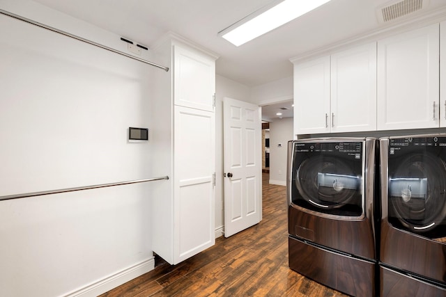 clothes washing area featuring independent washer and dryer, cabinet space, dark wood finished floors, and baseboards