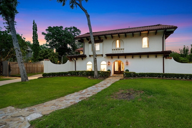 mediterranean / spanish house with stucco siding, a tile roof, and french doors