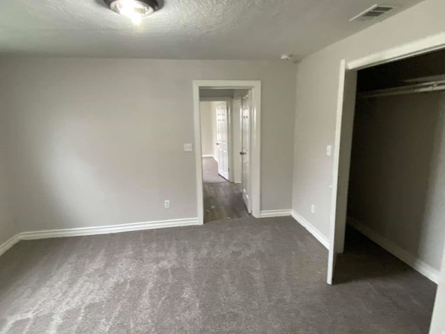7015 Boyce St, Houston, TX 77020 - unfurnished bedroom with carpet flooring, a closet, baseboards, and a textured ceiling