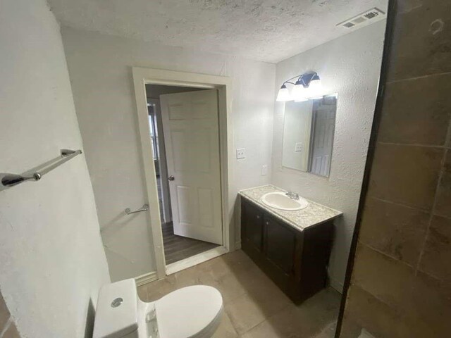7015 Boyce St, Houston, TX 77020 - bathroom with a textured ceiling, vanity, and toilet