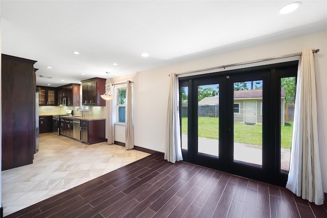 5418 Poinciana Dr, Houston, TX 77092 - kitchen with plenty of natural light, dark brown cabinets, stainless steel appliances, a sink, and recessed lighting