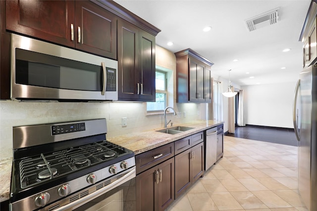 5418 Poinciana Dr, Houston, TX 77092 - kitchen with stainless steel appliances, a sink, backsplash, light stone counters, and recessed lighting