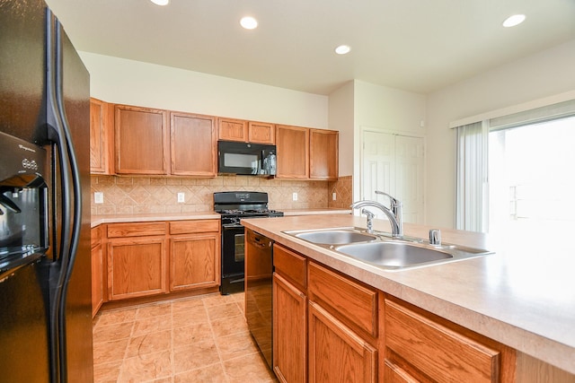 kitchen featuring black appliances, a sink, light countertops, tasteful backsplash, and recessed lighting