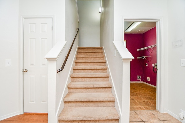 stairway with tile patterned flooring and baseboards
