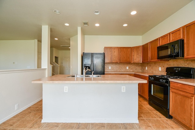 kitchen with black appliances, a sink, an island with sink, light countertops, and recessed lighting