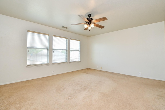 empty room with light colored carpet, ceiling fan, and baseboards