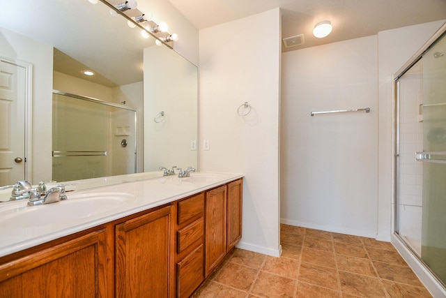 bathroom featuring a stall shower, double vanity, and baseboards