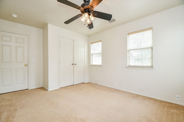 unfurnished bedroom with light colored carpet, baseboards, and a closet
