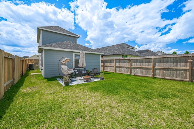 back of house featuring a fire pit, roof with shingles, and a patio area
