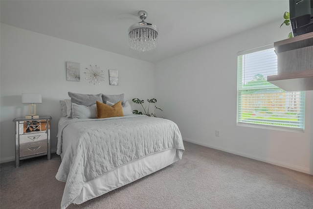 bedroom featuring a chandelier, baseboards, and carpet