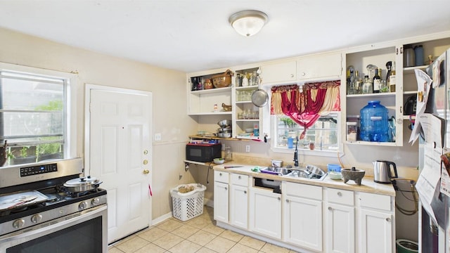 8935 Duane St, Houston, TX 77051 - kitchen with gas range, open shelves, black microwave, light countertops, and light tile patterned flooring