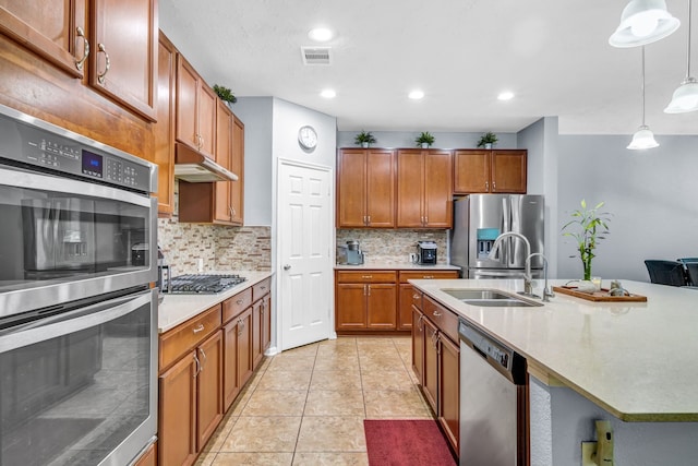 20703 Fawn Timber Trl, Humble, TX 77346 - kitchen featuring stainless steel appliances, a sink, under cabinet range hood, backsplash, and brown cabinetry