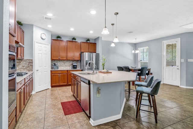 20703 Fawn Timber Trl, Humble, TX 77346 - kitchen featuring stainless steel appliances, tasteful backsplash, a sink, brown cabinets, and a breakfast bar area