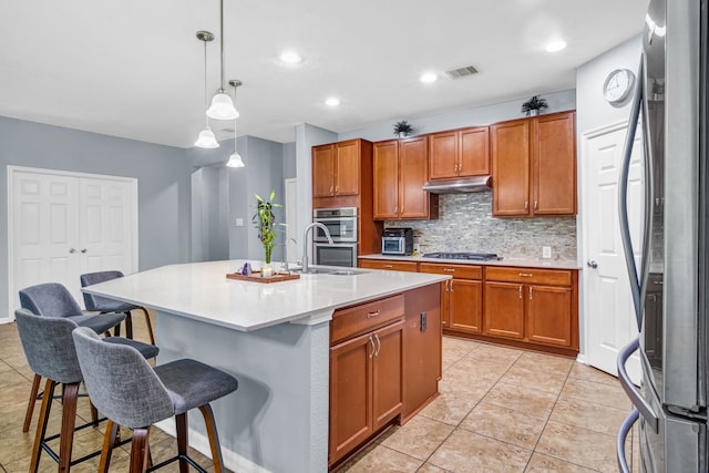 20703 Fawn Timber Trl, Humble, TX 77346 - kitchen with appliances with stainless steel finishes, under cabinet range hood, backsplash, a kitchen breakfast bar, and light countertops