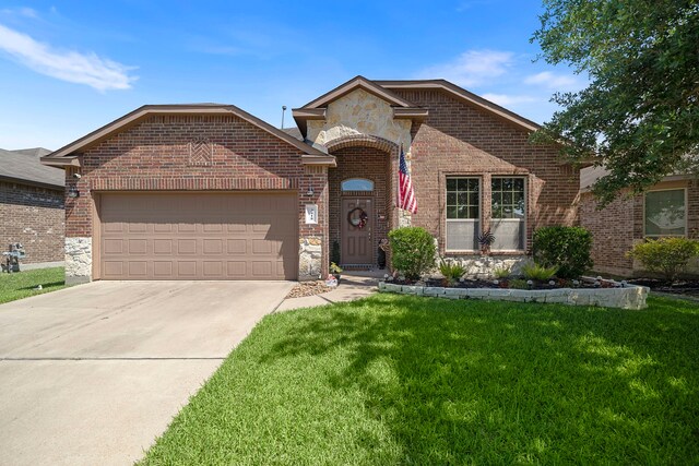 3418 Daniel Falls Ln, Katy, TX 77449 - french country home with brick siding, an attached garage, a front yard, concrete driveway, and stone siding