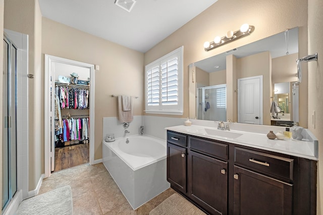 3418 Daniel Falls Ln, Katy, TX 77449 - bathroom featuring a shower stall, vanity, a bath, a spacious closet, and tile patterned floors