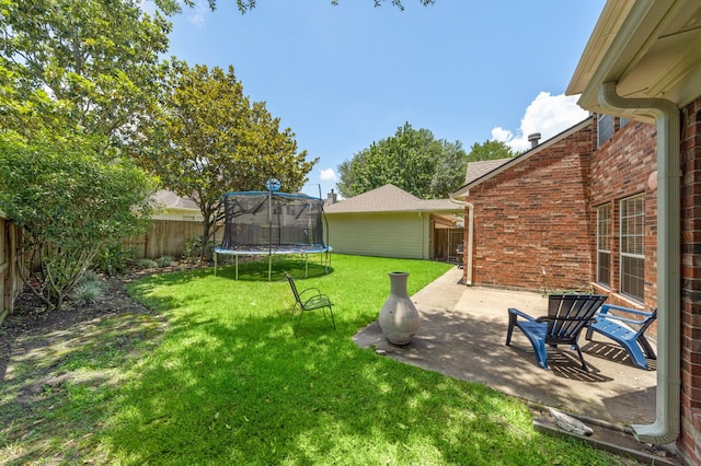 view of yard with a trampoline and a patio area