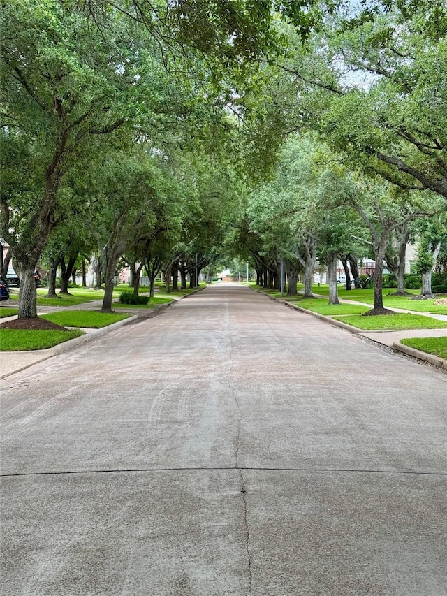 view of concrete street featuring curbs and sidewalks