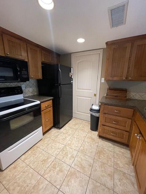 52 April Hl Unit 52, Conroe, TX 77356 - kitchen featuring black appliances, dark countertops, decorative backsplash, brown cabinets, and light tile patterned flooring