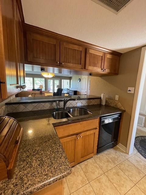 52 April Hl Unit 52, Conroe, TX 77356 - kitchen featuring black dishwasher, a sink, brown cabinets, light tile patterned floors, and dark stone counters